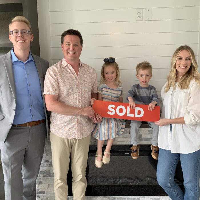 Howsare and a family holding a sold sign